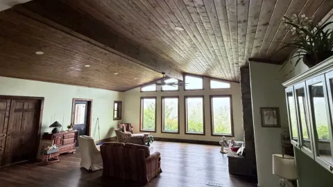 Living room addition with a vaulted wood ceiling and mountain-view windows, built by Highlander in Franklin, North Carolina